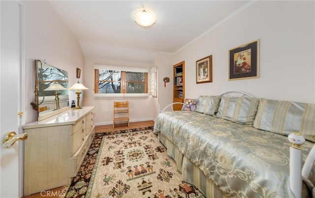 bedroom with crown molding, light wood-type flooring, and baseboards