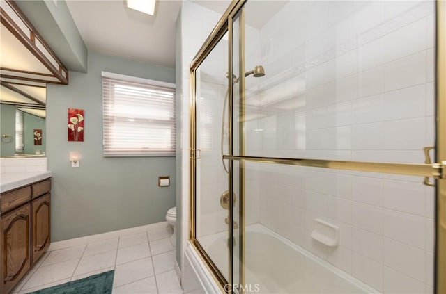 full bathroom with bath / shower combo with glass door, toilet, vanity, tile patterned flooring, and baseboards