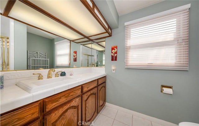 bathroom featuring baseboards, vanity, a shower with door, and tile patterned floors