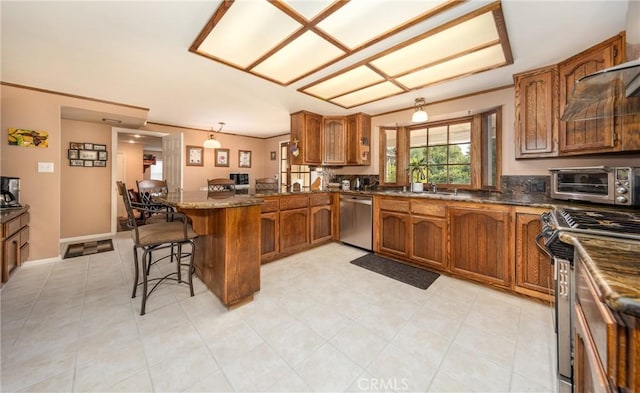 kitchen featuring stainless steel appliances, a toaster, brown cabinetry, and a kitchen breakfast bar