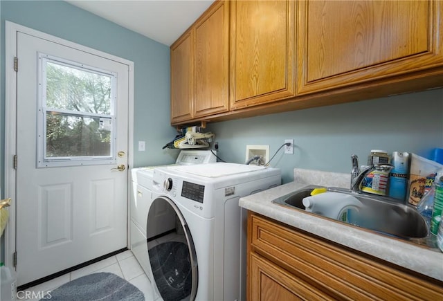 washroom with light tile patterned floors, a sink, cabinet space, and washer and dryer