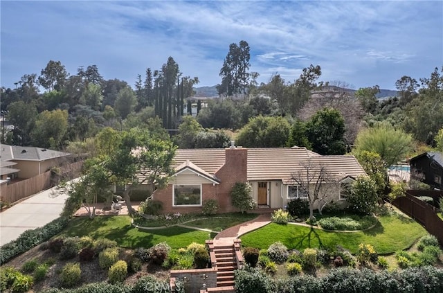 view of front of home featuring fence, a chimney, a front lawn, and stairs