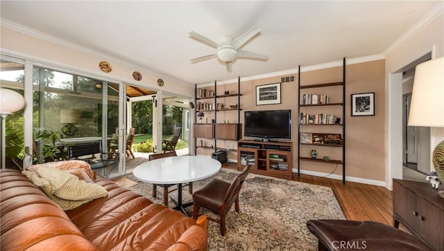 living area featuring ornamental molding, wood finished floors, a ceiling fan, and baseboards