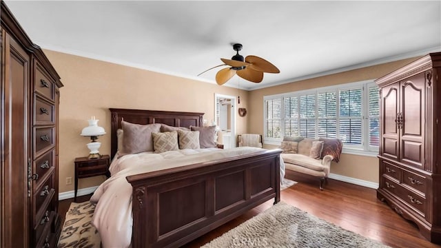 bedroom featuring dark wood-style floors, baseboards, ornamental molding, and a ceiling fan