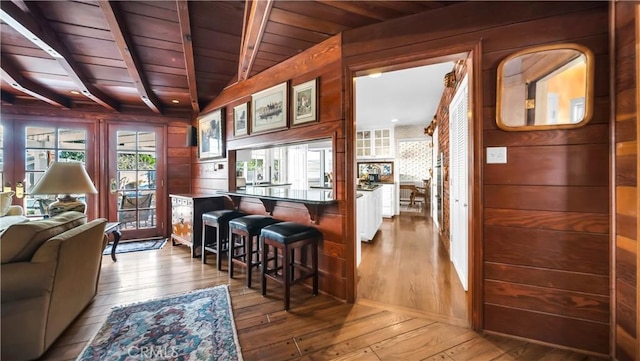 interior space featuring wooden ceiling, wood walls, hardwood / wood-style floors, and beamed ceiling