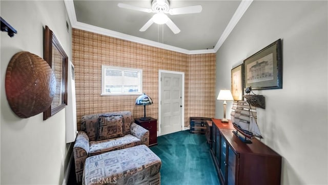 sitting room featuring ornamental molding, dark colored carpet, wallpapered walls, and a ceiling fan