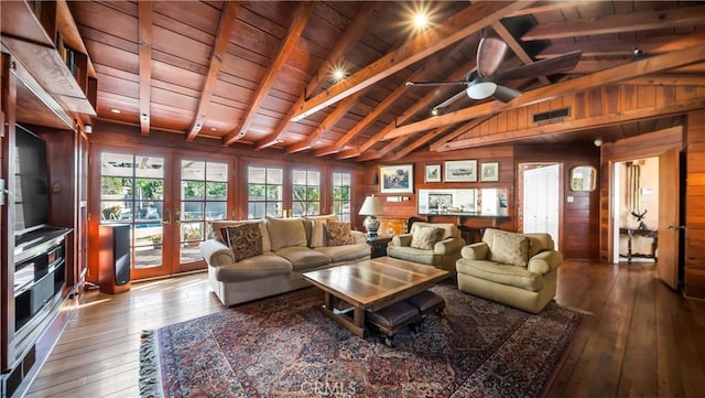 living room with vaulted ceiling with beams, wooden ceiling, dark wood finished floors, and wooden walls