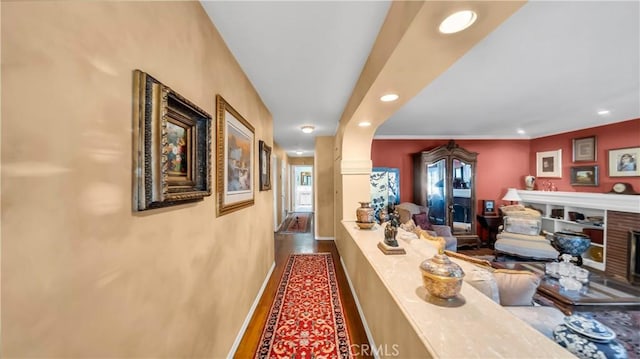 hallway with baseboards, wood finished floors, and recessed lighting