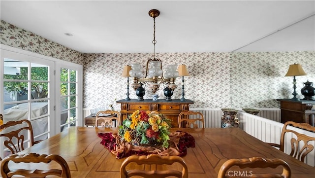 dining room with an inviting chandelier and wallpapered walls