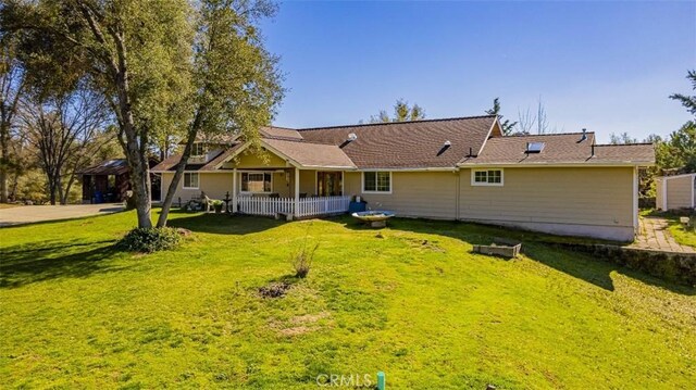 45544 Pine River Rd, Ahwahnee, CA 93601 - rear view of house with a porch and a lawn