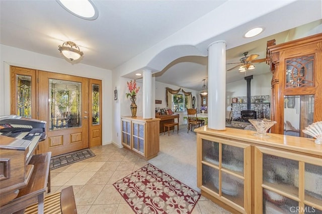 45544 Pine River Rd, Ahwahnee, CA 93601 - foyer featuring a wood stove, light tile patterned floors, ornate columns, and lofted ceiling