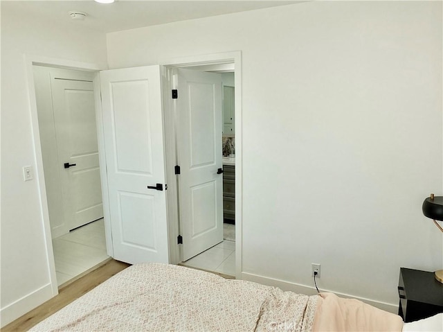 bedroom with light wood-style floors and baseboards