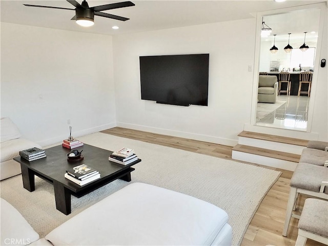 living area with ceiling fan, recessed lighting, wood finished floors, and baseboards