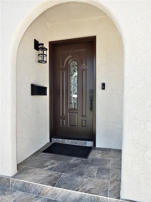 view of exterior entry featuring stucco siding