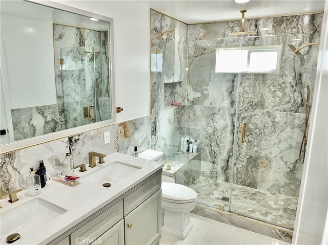 bathroom with toilet, a sink, tile walls, and a marble finish shower