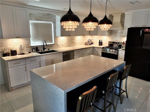 kitchen with backsplash, stainless steel gas stove, a sink, wall chimney range hood, and dishwashing machine