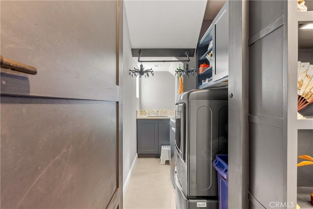 clothes washing area with a sink, washer / clothes dryer, and cabinet space