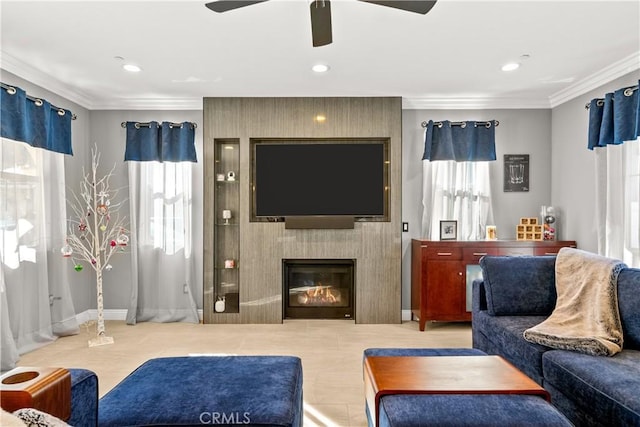 tiled living area with recessed lighting, a large fireplace, ceiling fan, and crown molding