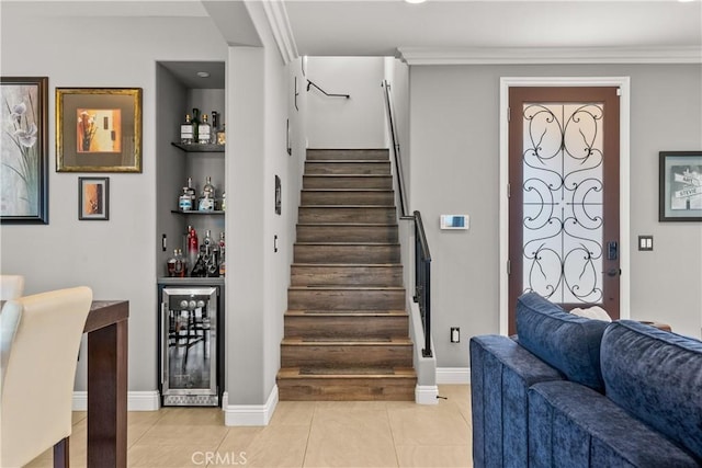 stairs featuring baseboards, beverage cooler, a dry bar, ornamental molding, and tile patterned floors