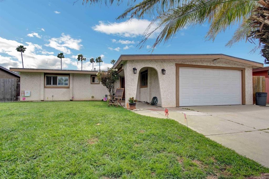 ranch-style home with stucco siding, an attached garage, a front yard, fence, and driveway