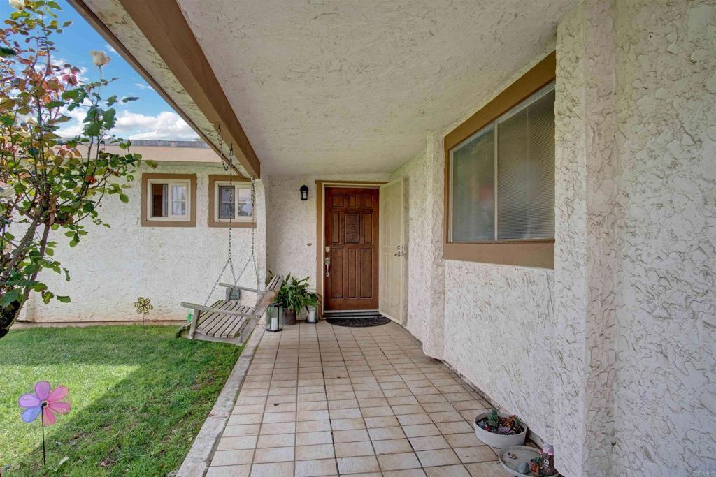 entrance to property with a lawn and stucco siding