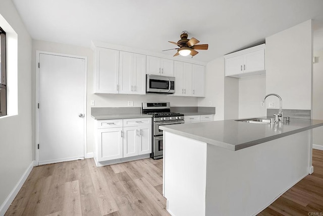 1331 Louden Ln, Imperial Beach, CA 91932 - kitchen featuring stainless steel appliances, light wood finished floors, a ceiling fan, and white cabinets