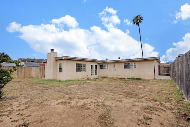 1331 Louden Ln, Imperial Beach, CA 91932 - rear view of house with stucco siding, french doors, a fenced backyard, and a chimney