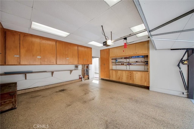 garage with baseboards and a garage door opener