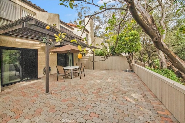 view of patio with fence, outdoor dining area, and a pergola