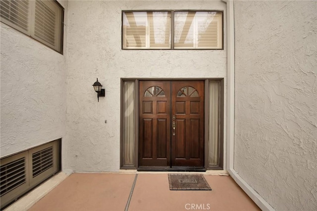 doorway to property featuring stucco siding