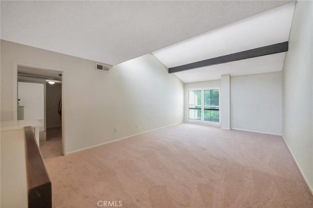 empty room with light carpet, beamed ceiling, visible vents, and baseboards