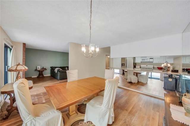 dining room with a notable chandelier and light wood-style flooring