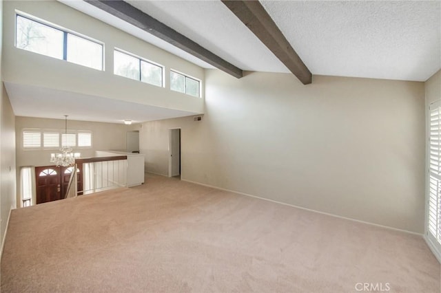 spare room featuring light carpet, an inviting chandelier, baseboards, and beam ceiling