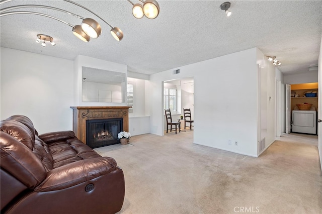 living room featuring a fireplace with flush hearth, visible vents, carpet floors, and a textured ceiling