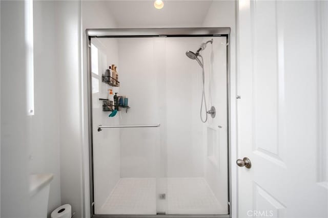 full bath featuring toilet and a stall shower