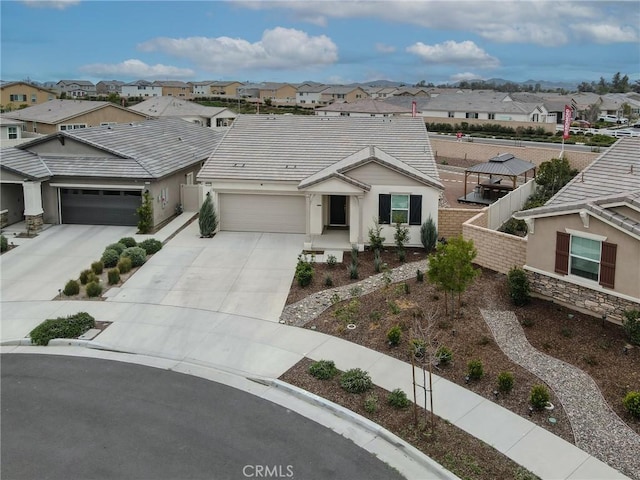 view of front of home with a garage, a residential view, concrete driveway, and stucco siding