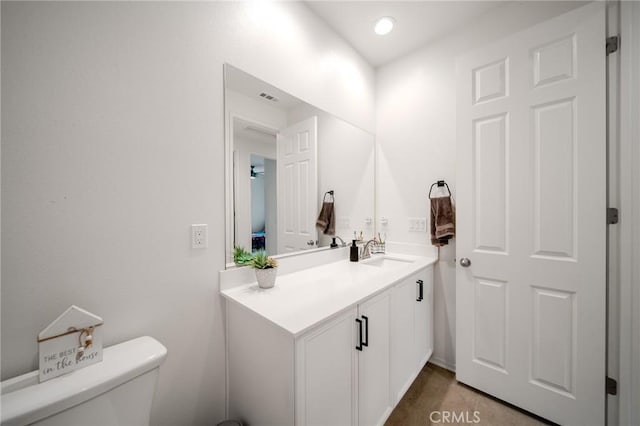 half bath featuring visible vents, vanity, and toilet