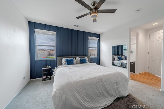 carpeted bedroom featuring ceiling fan and visible vents