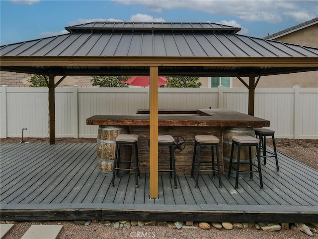 wooden deck featuring outdoor dry bar, a gazebo, and fence