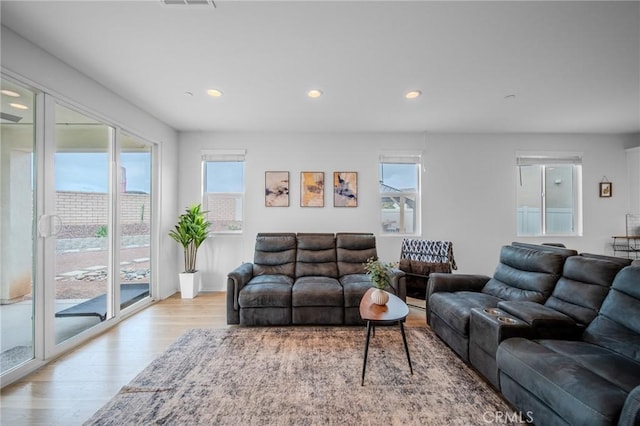 living area featuring recessed lighting, a healthy amount of sunlight, and wood finished floors