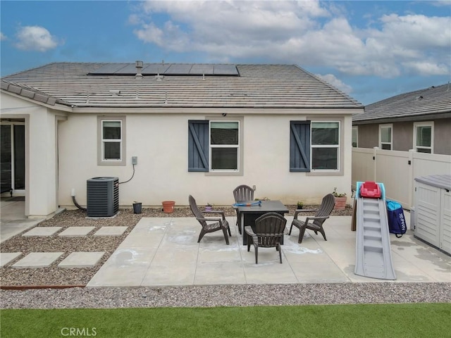 back of house with a patio, central AC, solar panels, fence, and stucco siding