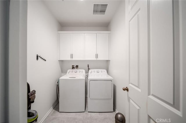 washroom with visible vents, cabinet space, washer and clothes dryer, and baseboards