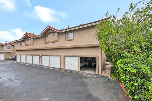 view of home's exterior with community garages and stucco siding