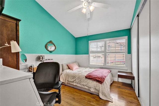 bedroom with hardwood / wood-style floors, vaulted ceiling, and a ceiling fan