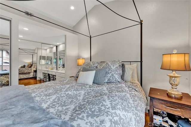 bedroom with wood finished floors and vaulted ceiling