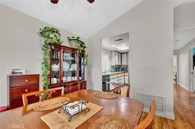 dining area featuring visible vents, lofted ceiling, a ceiling fan, and light wood finished floors