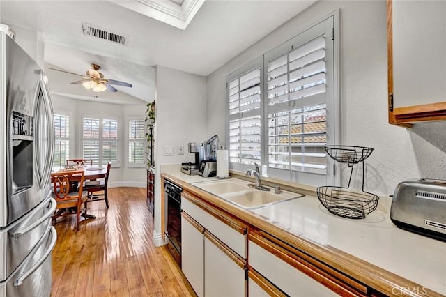 kitchen with visible vents, a sink, stainless steel fridge, a skylight, and dishwasher