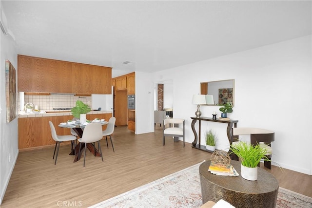 dining room featuring light wood finished floors and baseboards