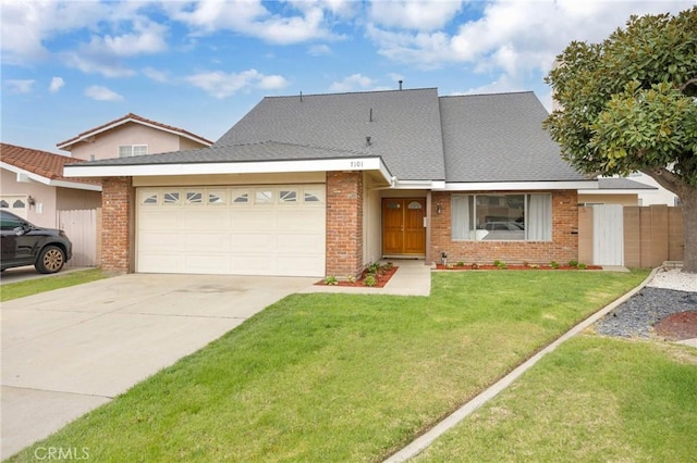 view of front of house with a front yard, fence, driveway, a garage, and brick siding