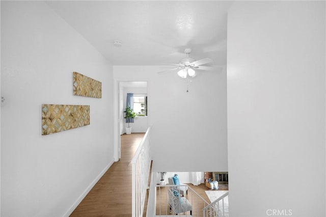 hall featuring baseboards and wood finished floors